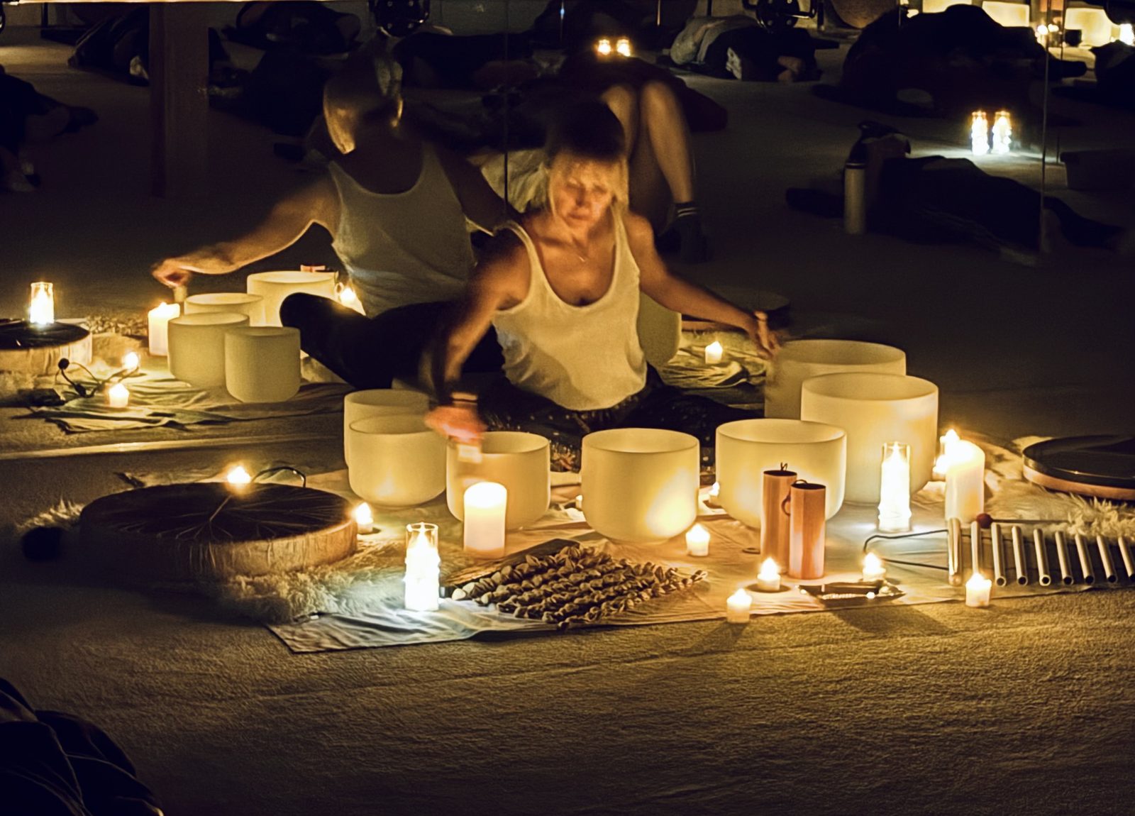Anna Christine Bowden playing crystal singing bowls at a candlelit sound bath