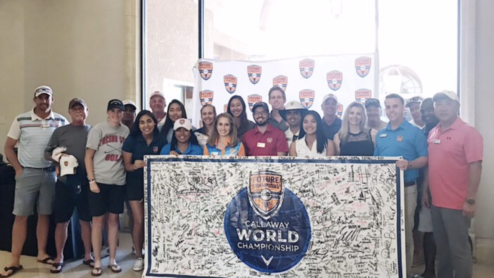 The Future Champions Golf staff and volunteers holding a signed FCG Callaway World Championship banner