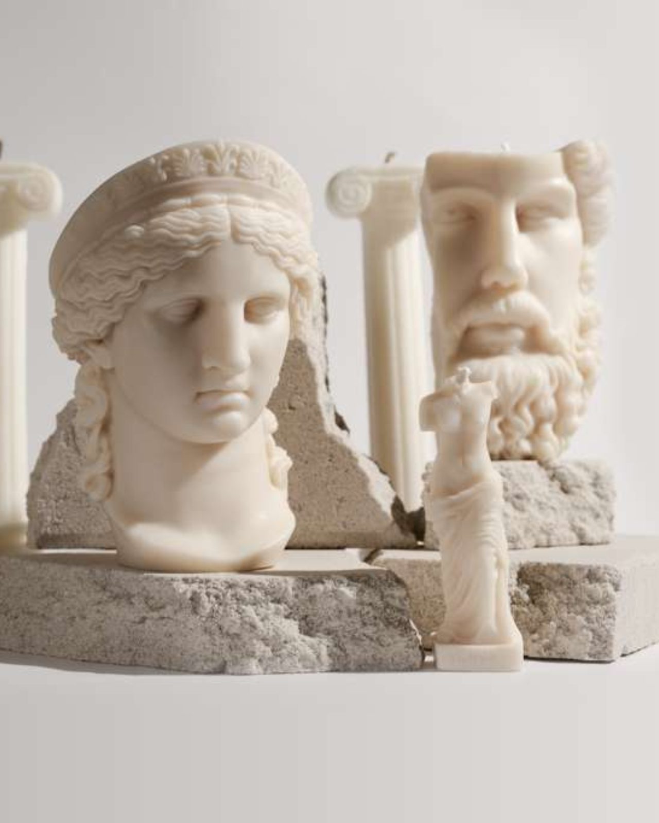Dahil Bar sculptural candles shaped like classical Greek busts, columns and a Venus figure, arranged on broken stone