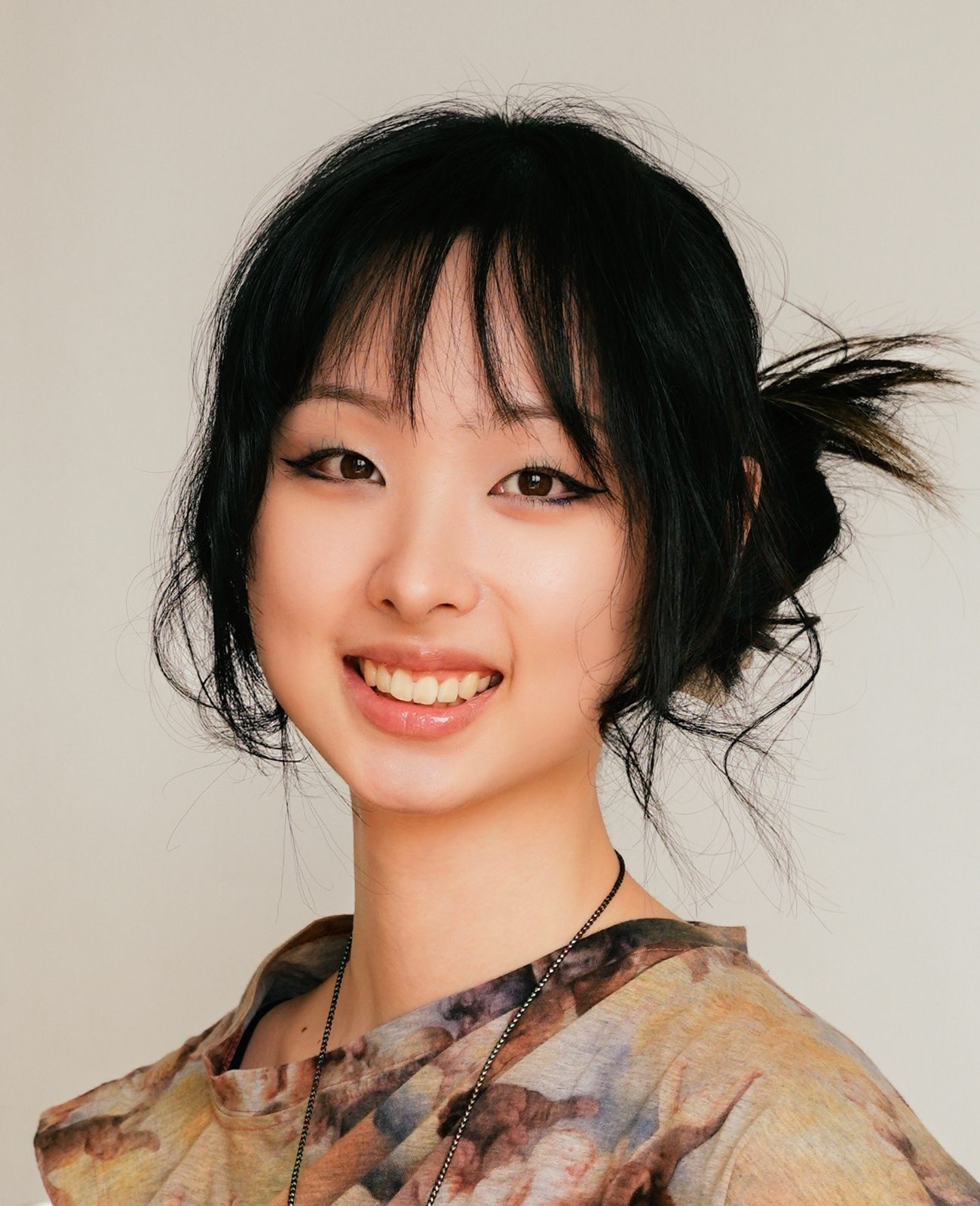 Huaixuan Xiang, also known as Chloe, painter and fantasy illustrator based in New York City, smiling in a printed top