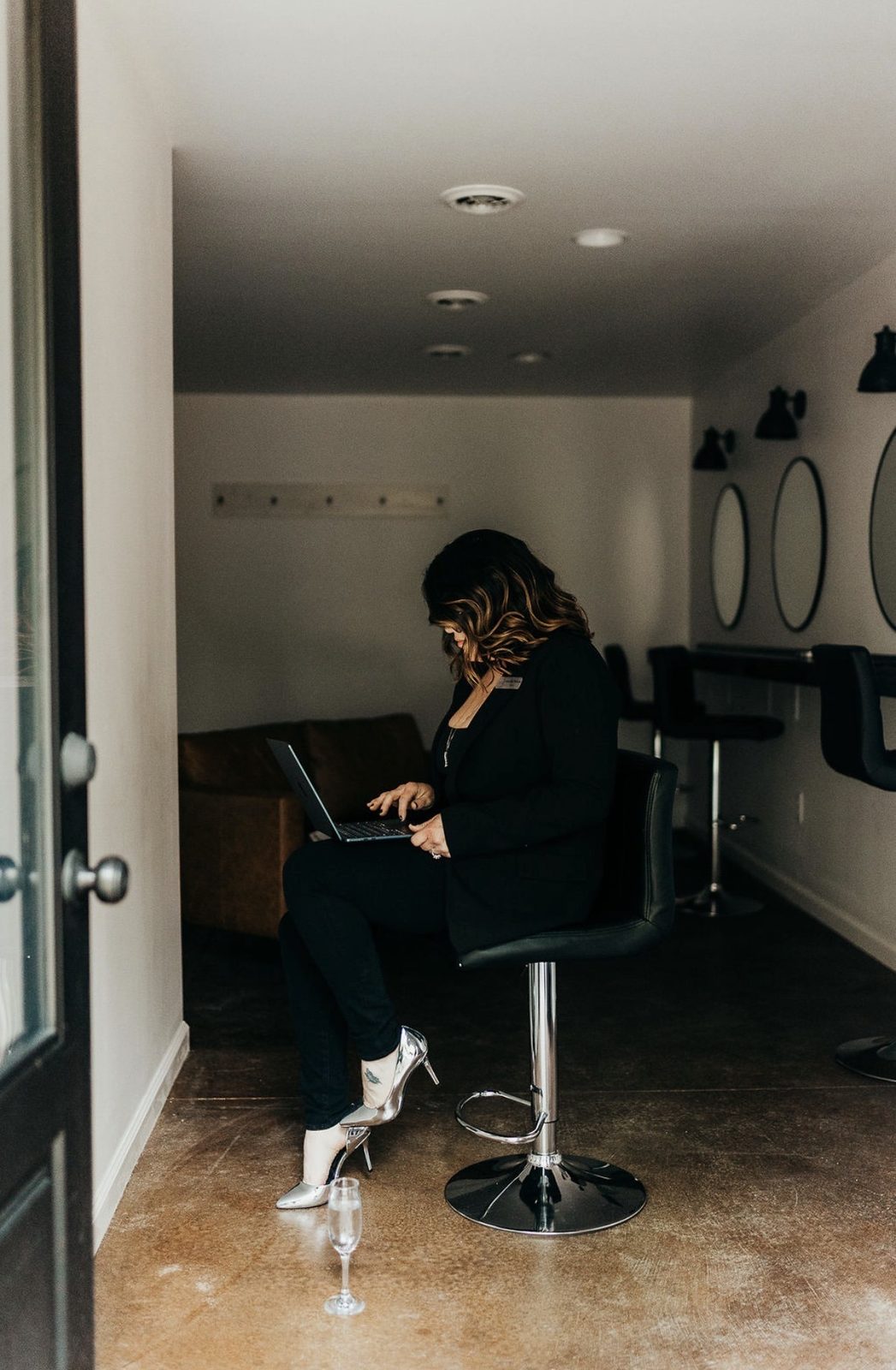 Jennifer Wilson working on a laptop in the bridal suite at Celestial Farms