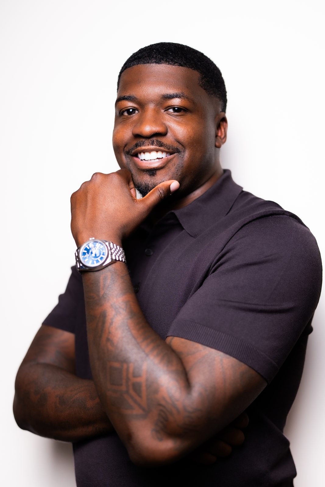 Karahn Alston, founder of Keeping Hopes Alive, smiling in a dark polo shirt with his hand at his chin