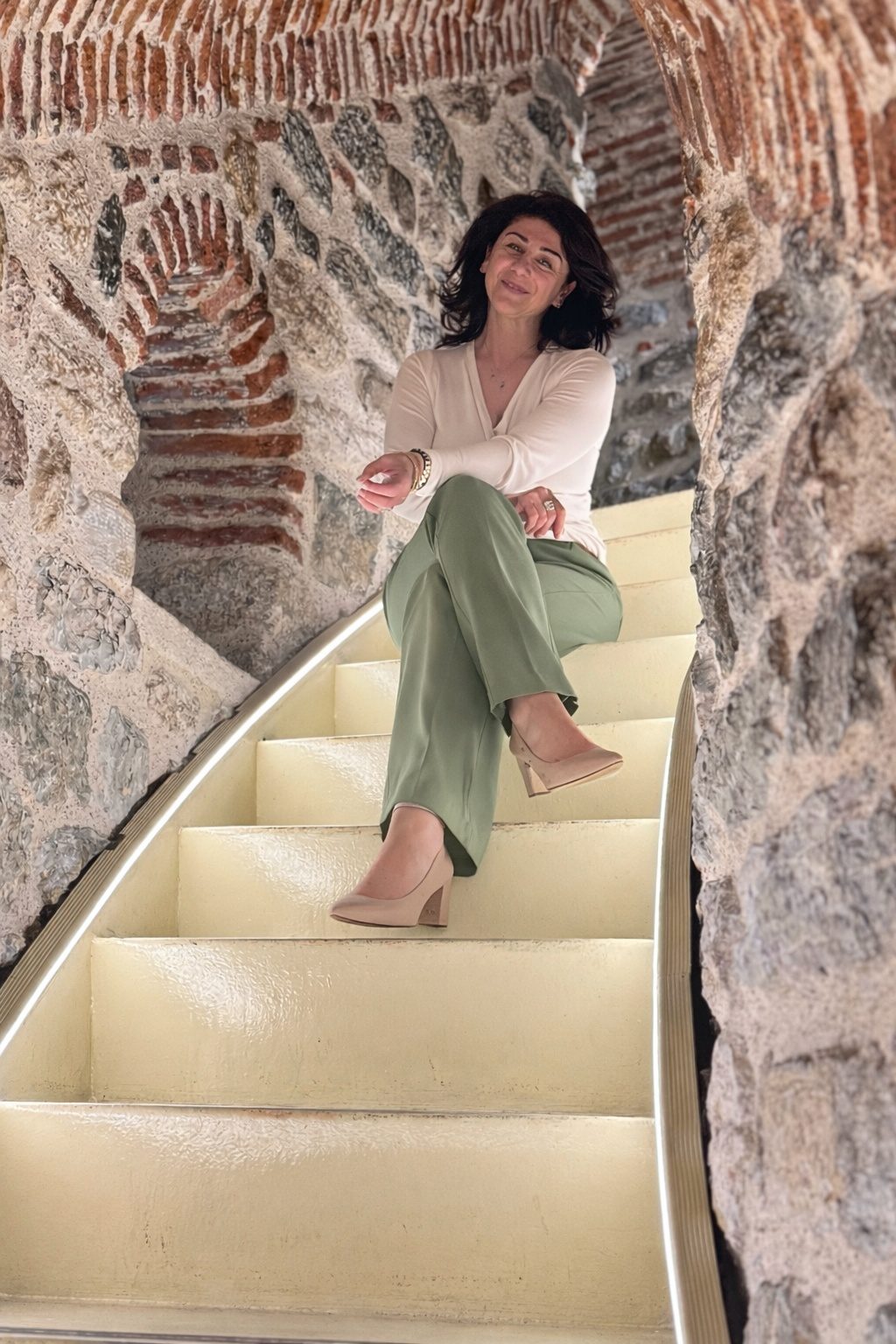 Kobi Julian seated on a curved stone staircase