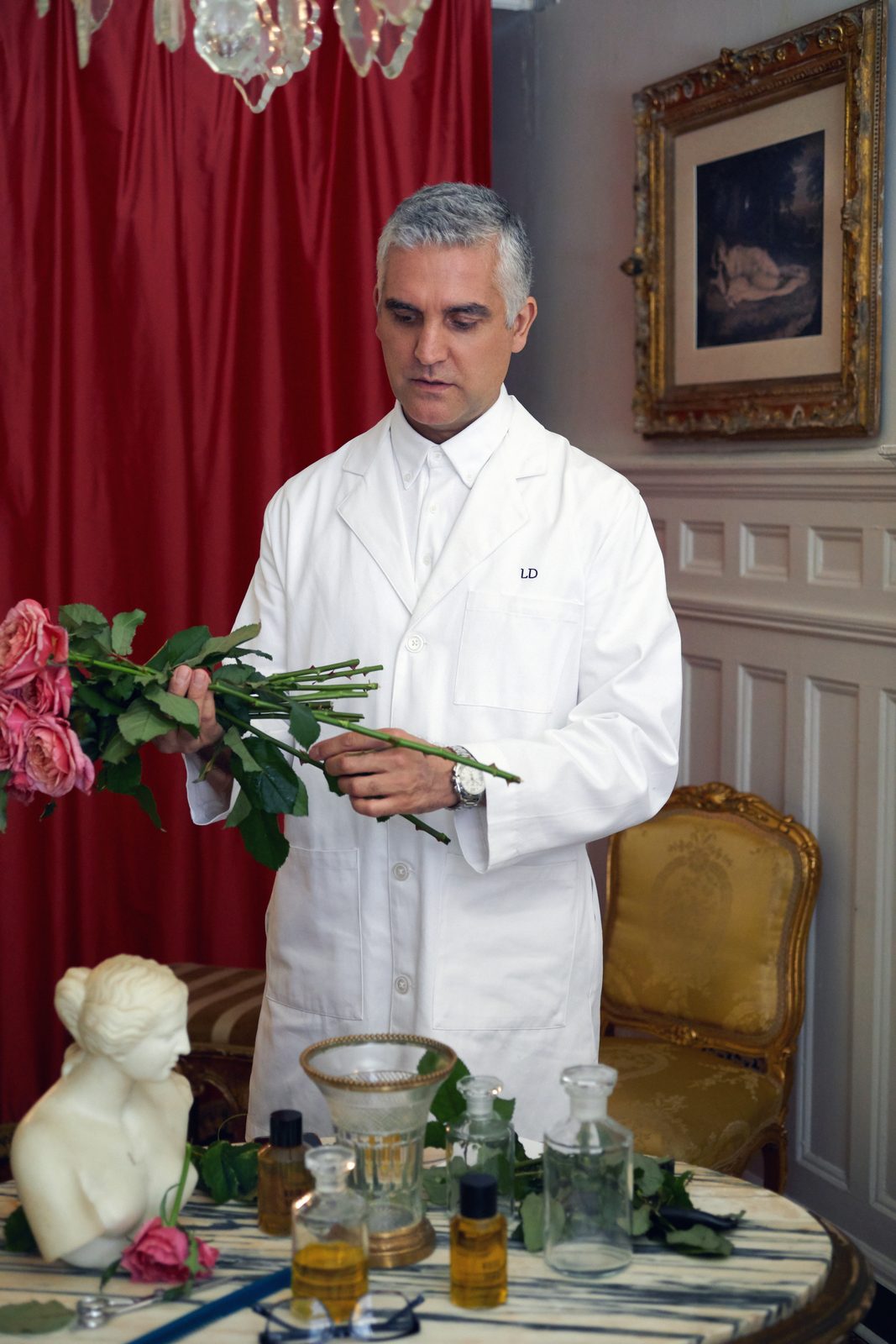 Lazarus Douvos, New York hairstylist and founder of Lazarus Douvos Hair & Fragrance, arranging roses in a white coat