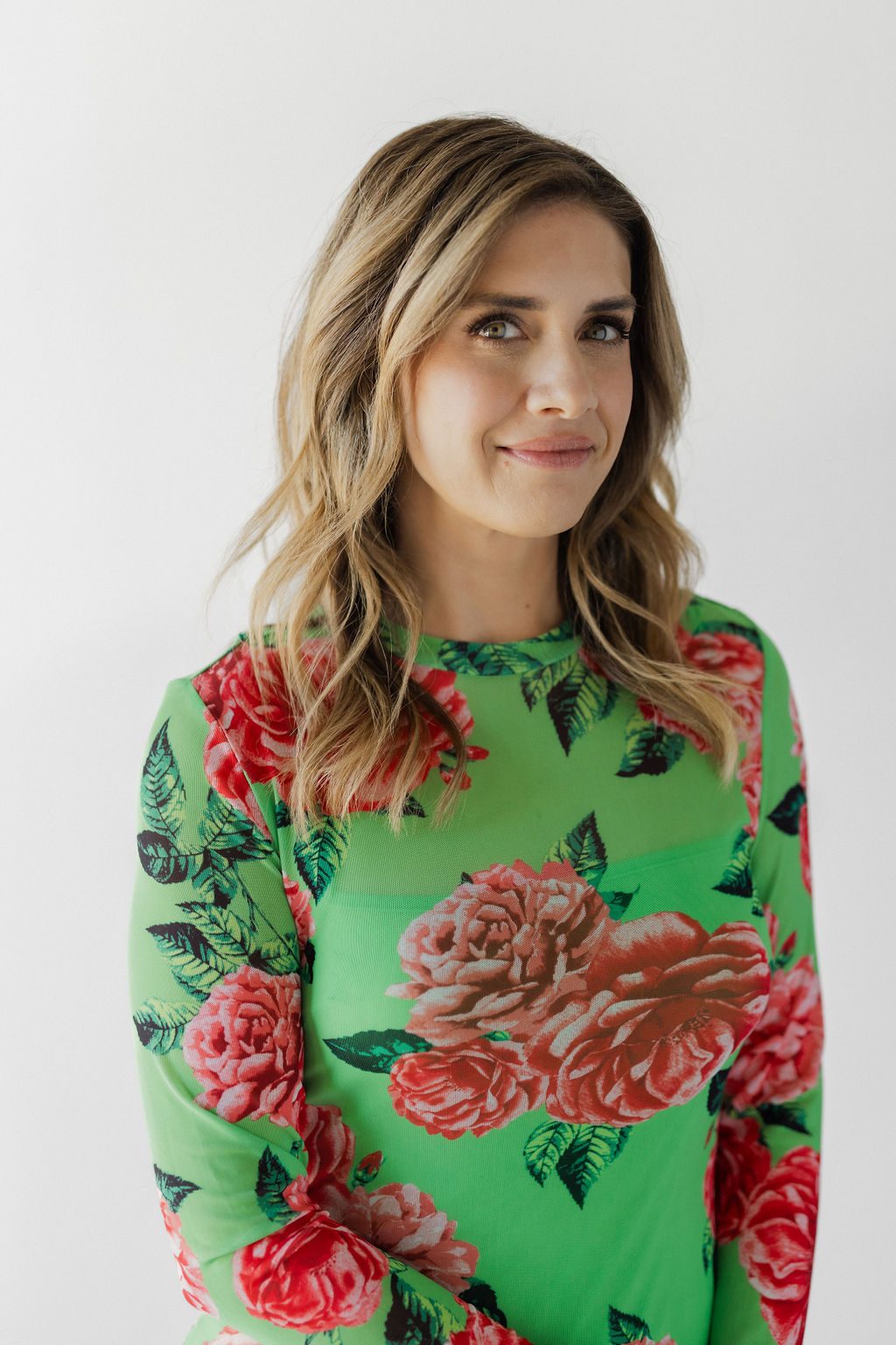Lisa Edwards, president and master colorist of Sunday Salon, in a green floral top against a white wall