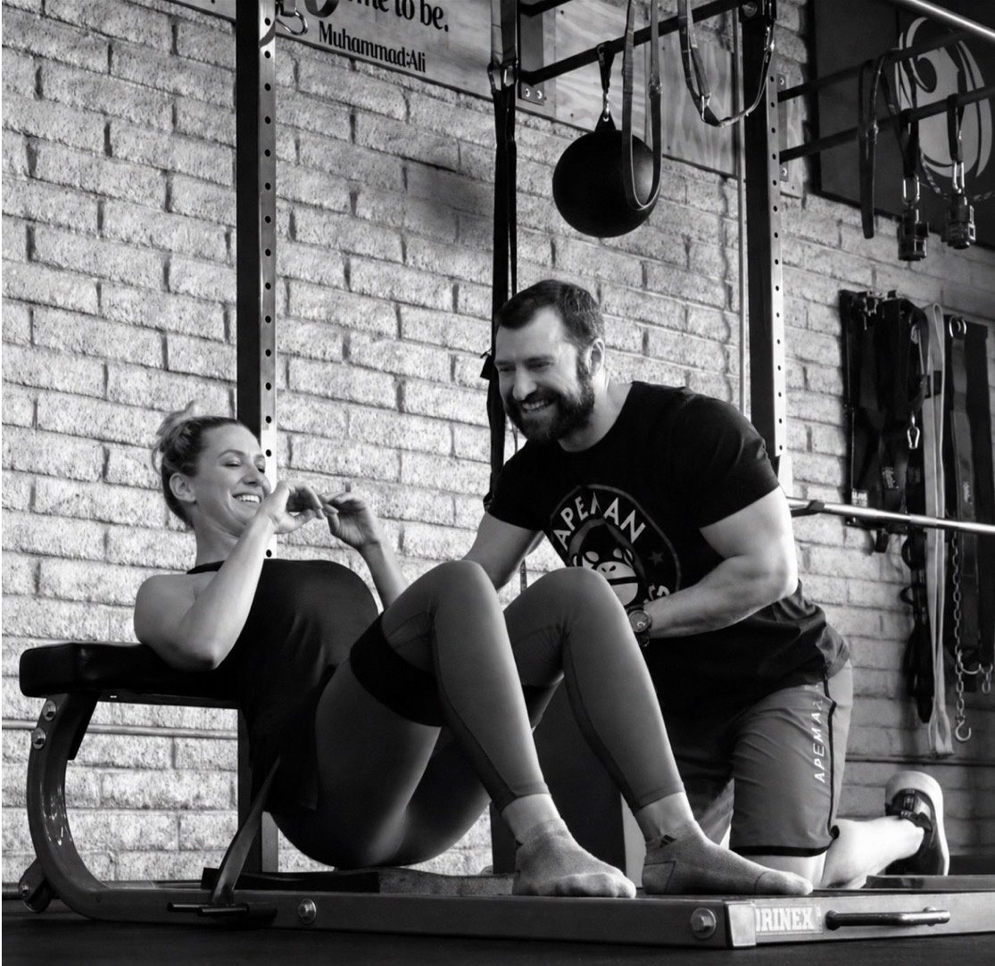 Matt Hitzhusen laughing with a client during a training session at HITZ Fitness