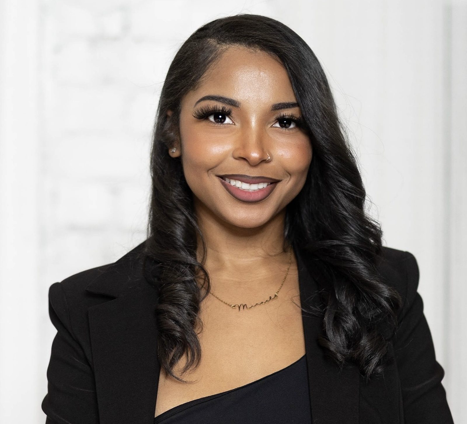 Miracle Flowers, founder of The Miracle Agency, smiling in a black blazer