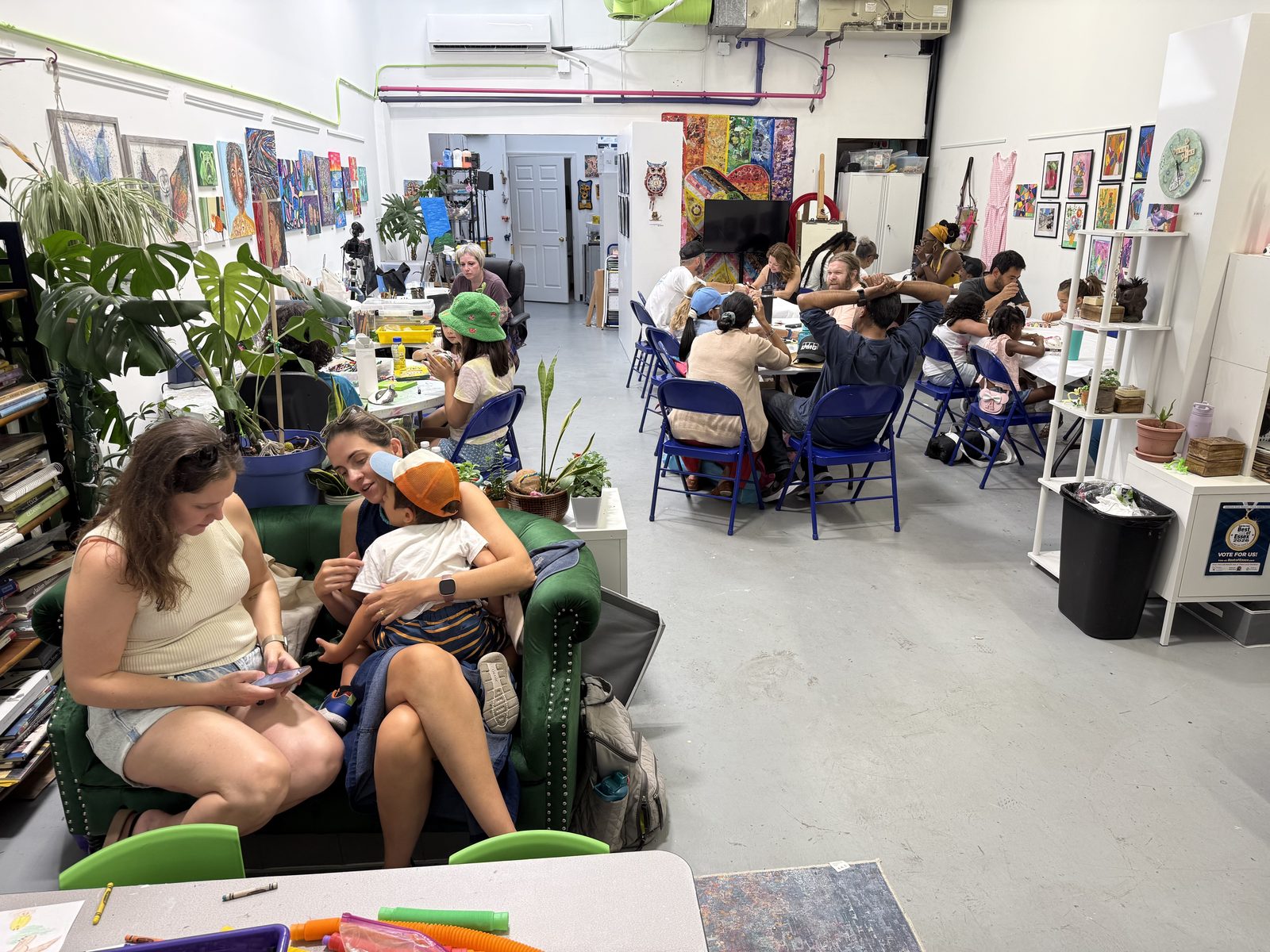 A class in session at Keep Creating Art Wellness Center, with participants of all ages working at tables around the studio