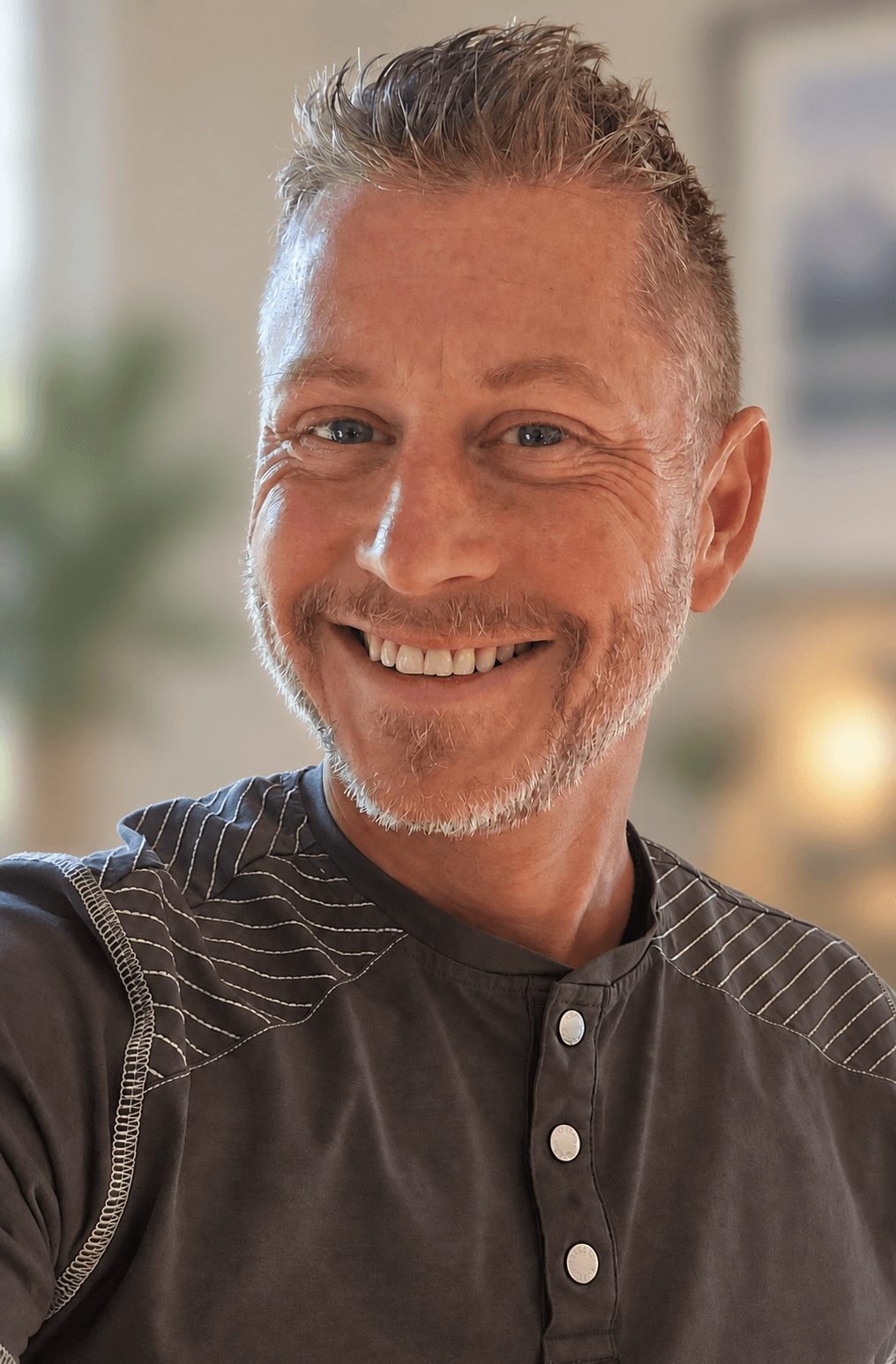 Paul McLellan, former owner of Service Lighting and LightBulbs.com, smiling in a grey henley