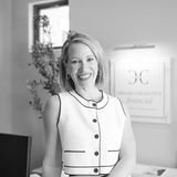 Angelina Creger, founder and CEO of Creger + Collective Financial, smiling in a black and white portrait in her office