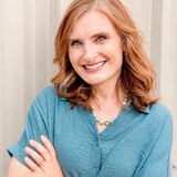 Elizabeth Geiger Harvey, founder of Renewal Therapeutics, smiling with her arms crossed in a teal blouse