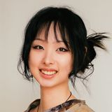 Huaixuan Xiang, also known as Chloe, painter and fantasy illustrator based in New York City, smiling in a printed top