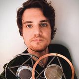 Joshua M. Lutz, founder of Lutz Multimedia and JML Studios, holding two vintage spring-mounted microphones