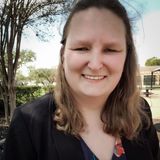 Katie Tschida, founder of KRT Virtual Assistant, smiling outdoors in a black blazer and floral top in Houston, Texas