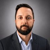 Mark Schneider, founder of Patrol Guard Security Services, in a dark suit and light blue shirt