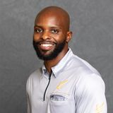 Milton Putman, founder and CEO of Complete Dominance Athletics, smiling in a grey CDA polo against a grey studio backdrop