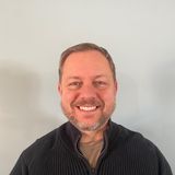 Richard Sias, owner of WeCare Solutions, smiling in a black zip sweater