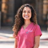 Shabnam Pedram Scott, DDS, co-owner of Gentle Dentistry of Poway, smiling in pink scrubs outside the practice in Poway, California