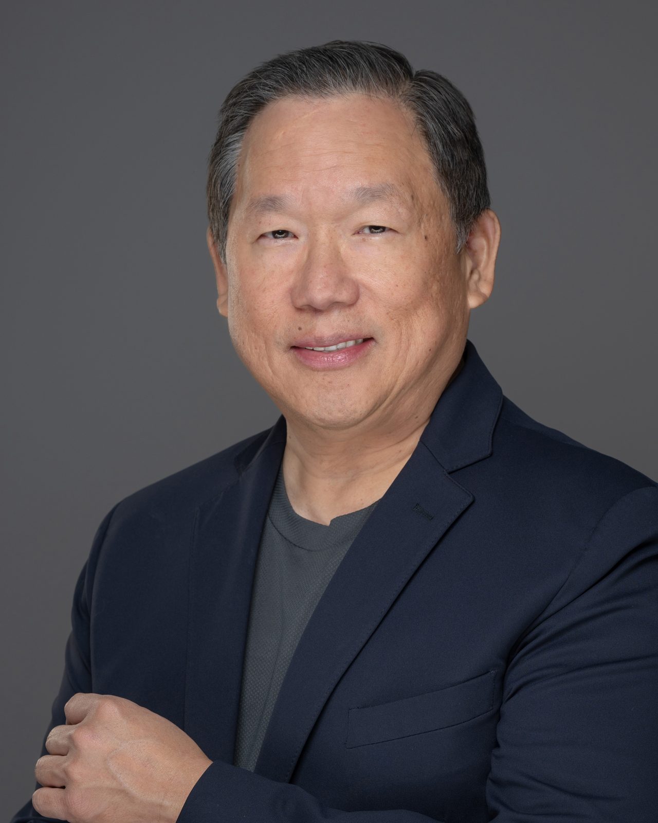 Will Lukang, founder of Kairos Elite Partnership, studio portrait in a navy blazer