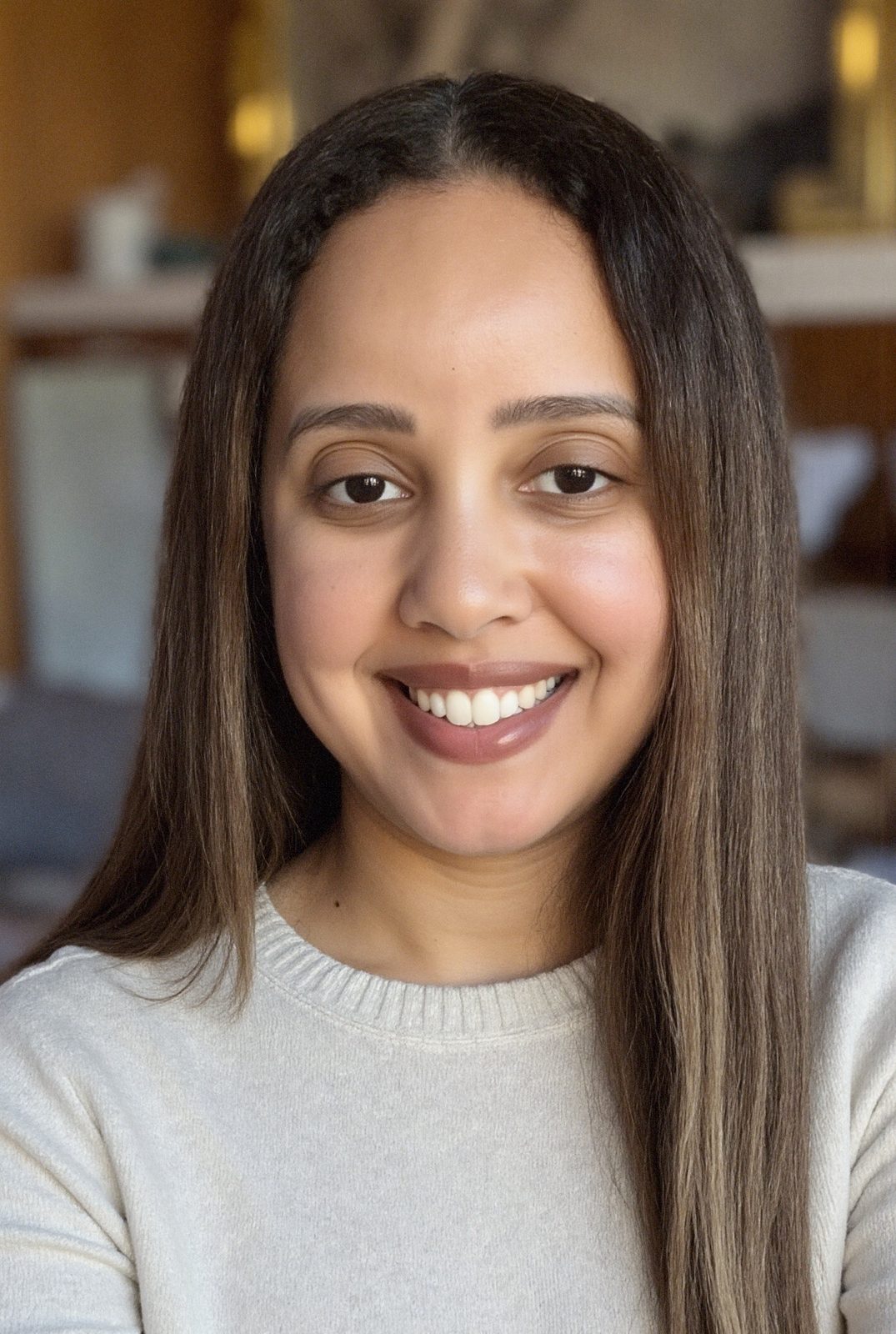 Yadira Fortunato smiling in a cream sweater, photographed indoors